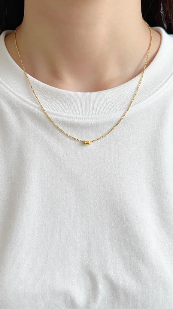 thin gold necklace on white tee neckline closeup