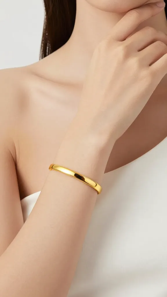 single gold cuff bracelet on model’s bare one-shoulder neckline